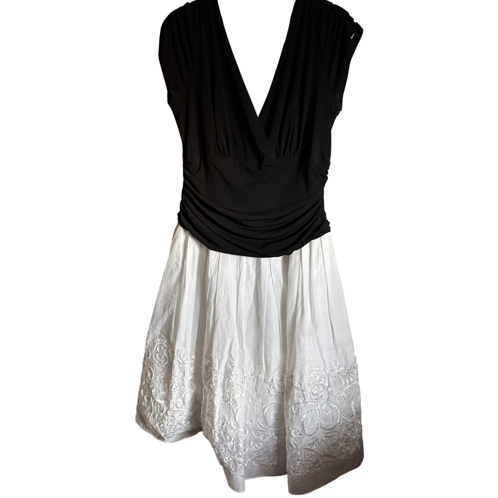 Dress with a fitted black‎ bodice and white skirt with detailed white embroidery